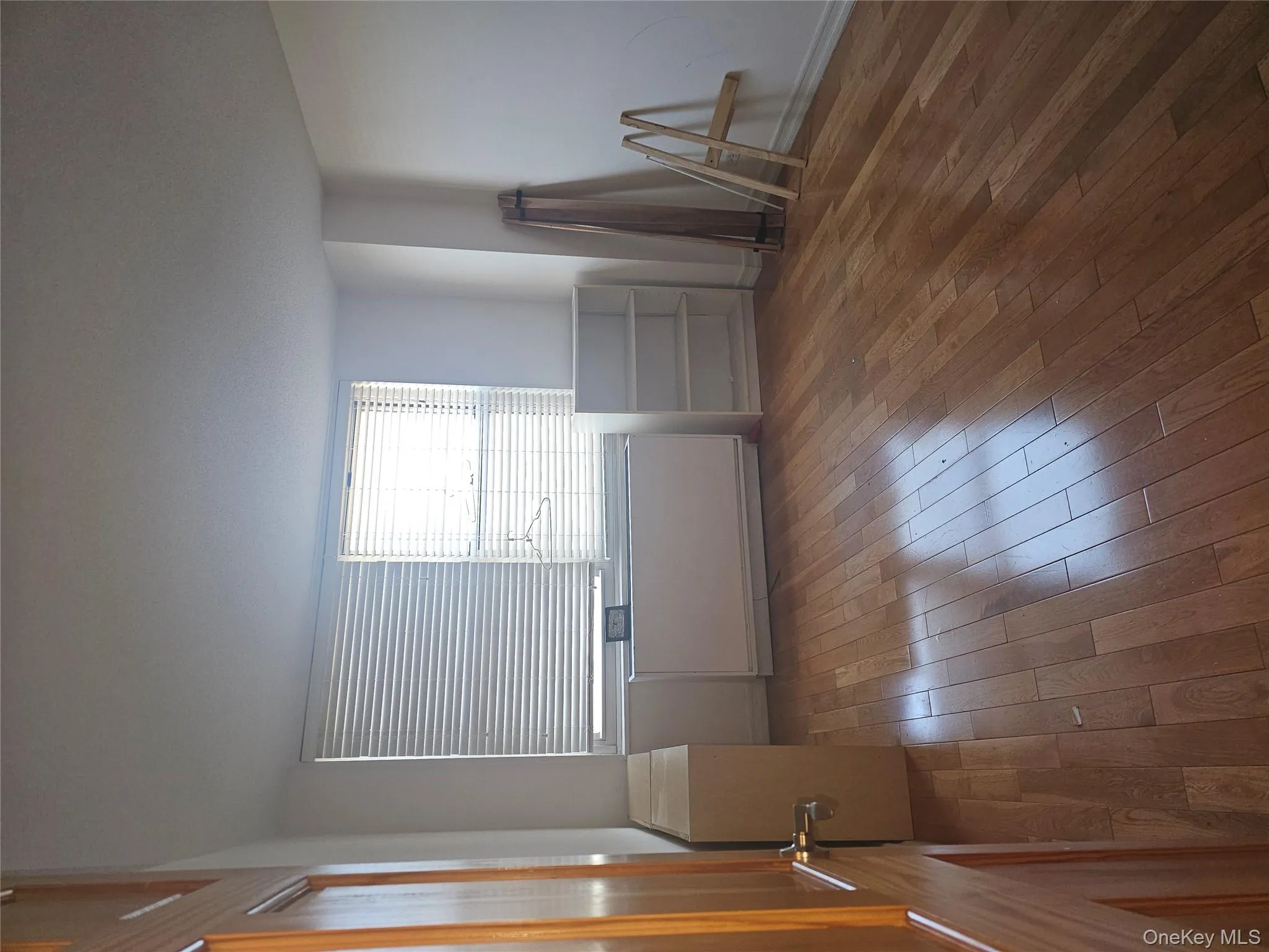 Spare room featuring radiator heating unit and dark wood-style flooring Spare room featuring radiator heating unit and dark wood-style flooring