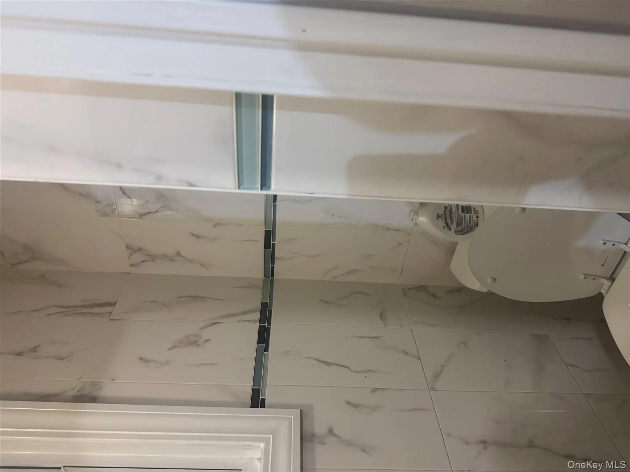 Bathroom featuring toilet and tile walls Bathroom featuring toilet and tile walls