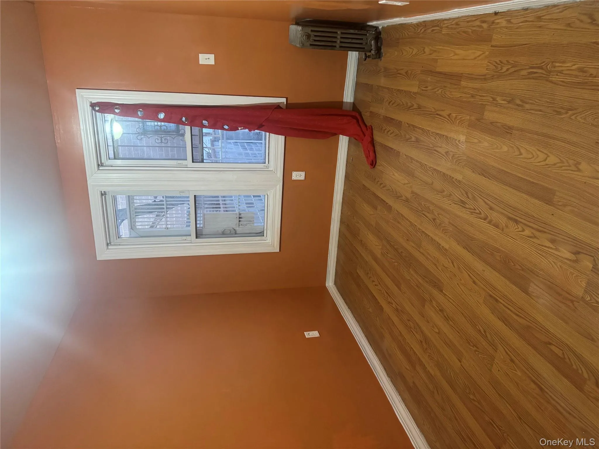 Unfurnished room with wood finished floors and radiator heating unit Unfurnished room with wood finished floors and radiator heating unit