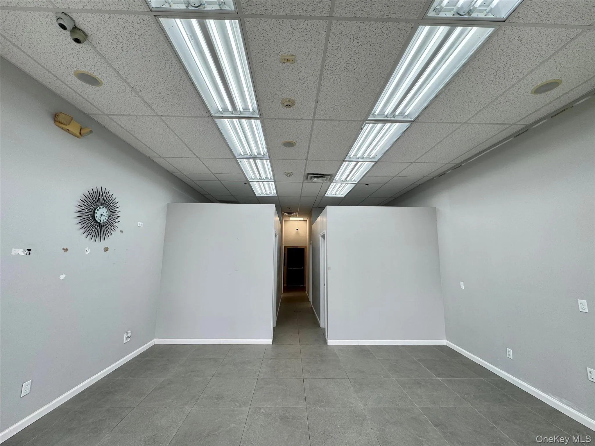 Basement with tile patterned floors and a paneled ceiling Basement with tile patterned floors and a paneled ceiling