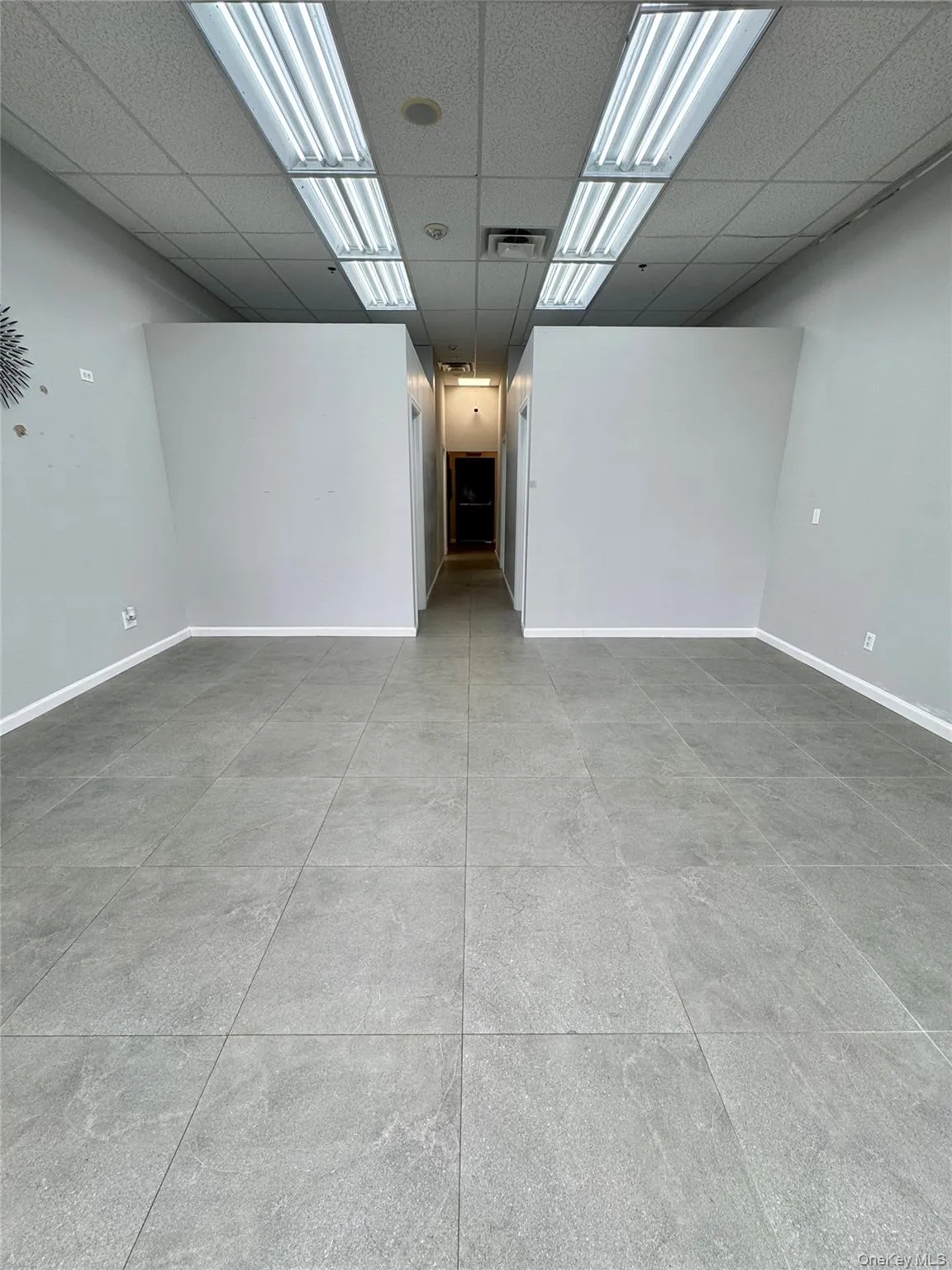 Basement featuring baseboards and a drop ceiling Basement featuring baseboards and a drop ceiling