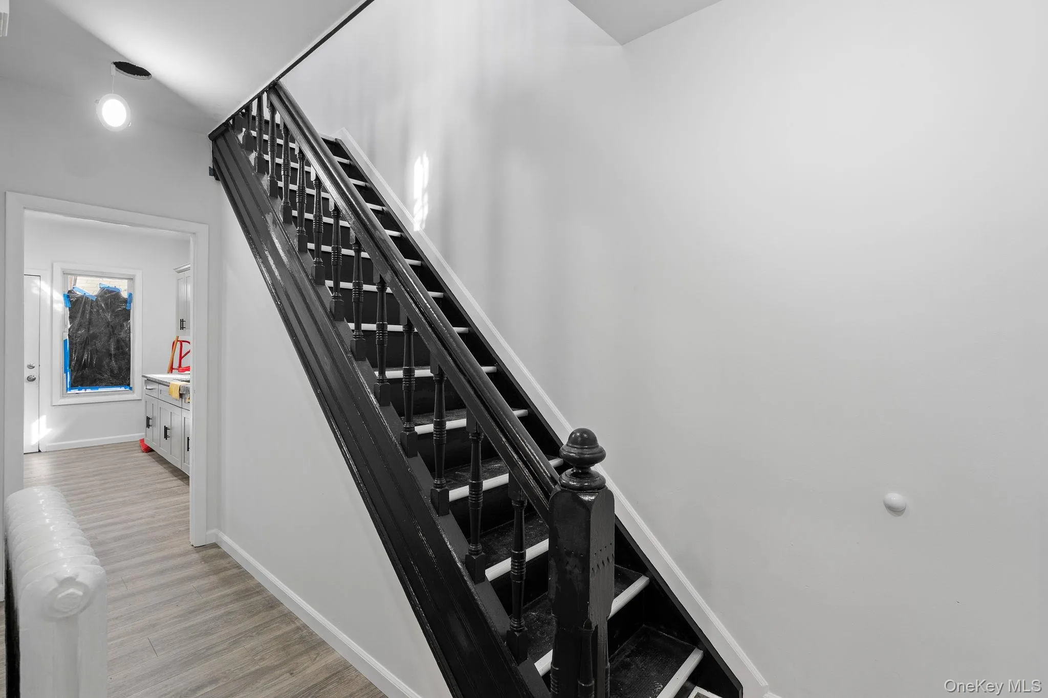 Stairway featuring radiator heating unit and wood finished floors Stairway featuring radiator heating unit and wood finished floors
