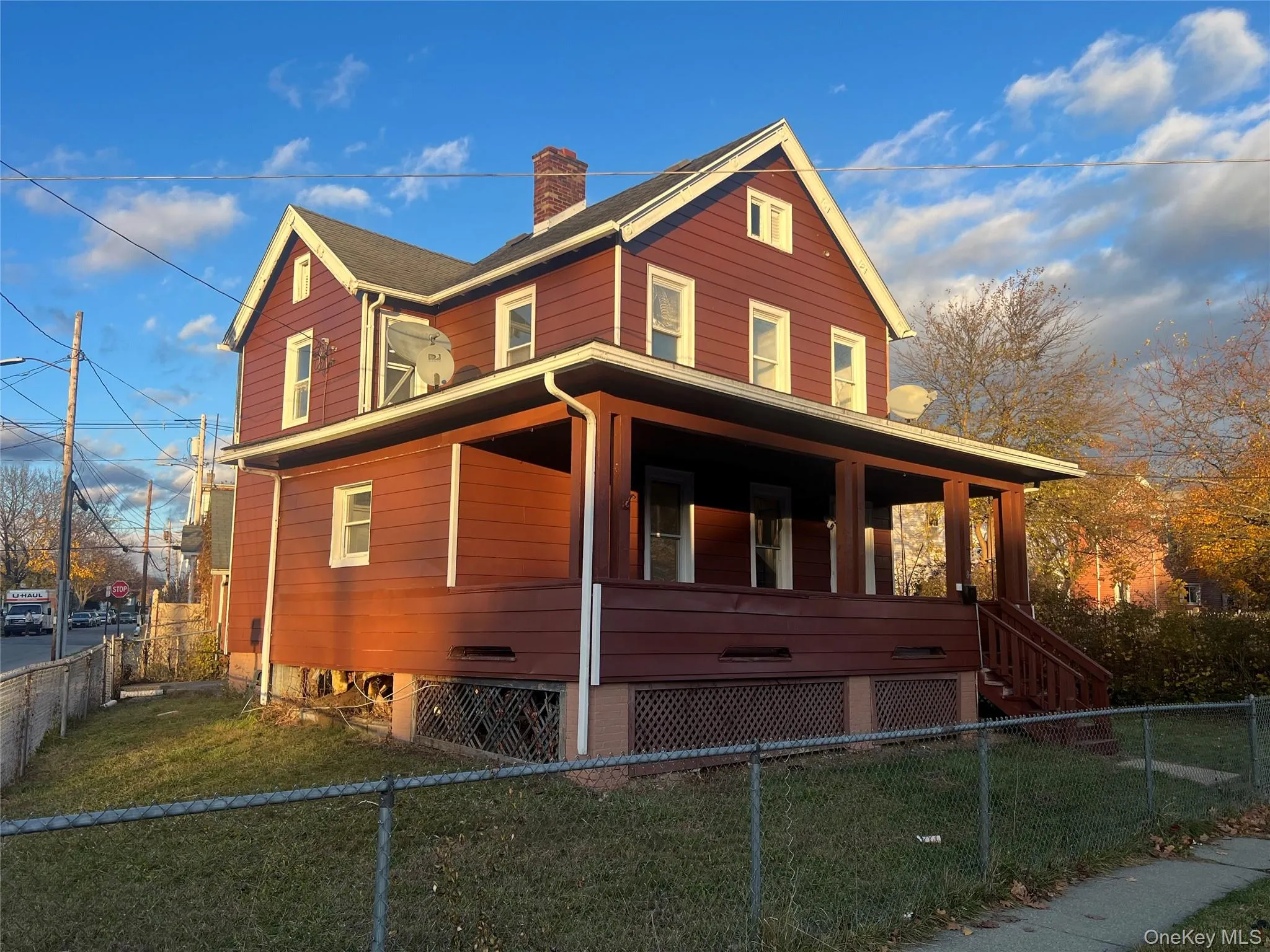 View of property exterior featuring covered porch, a chimney, a fenced front yard, and stairs View of property exterior featuring covered porch, a chimney, a fenced front yard, and stairs