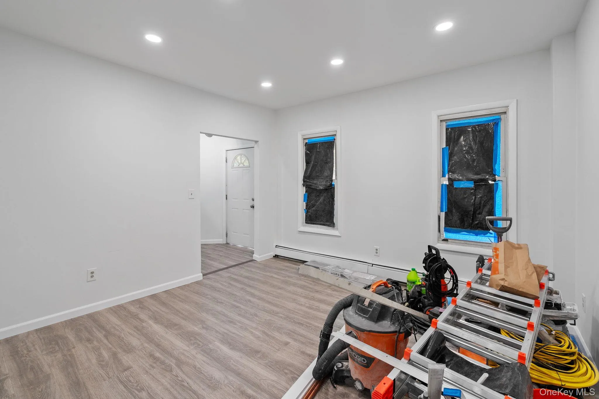 Workout area with wood finished floors, recessed lighting, and a baseboard heating unit Workout area with wood finished floors, recessed lighting, and a baseboard heating unit