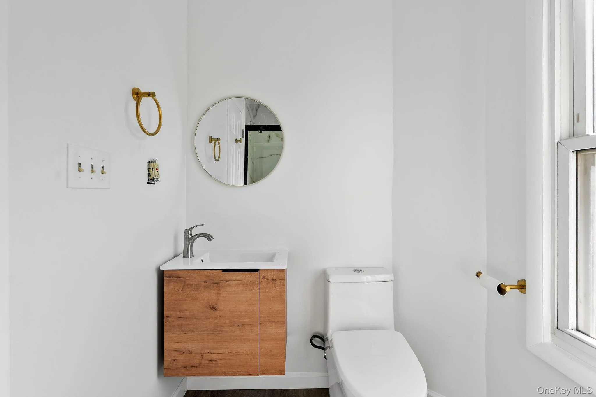 Full bath with vanity, a shower with curtain, and wood finished floors Full bath with vanity, a shower with curtain, and wood finished floors