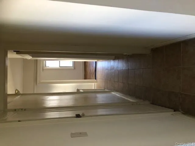 Hall with light tile patterned floors and baseboards Hall with light tile patterned floors and baseboards