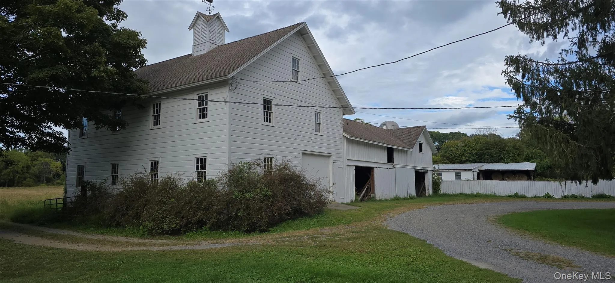 View of side of home with driveway, an attached garage, and a shingled roof View of side of home with driveway, an attached garage, and a shingled roof