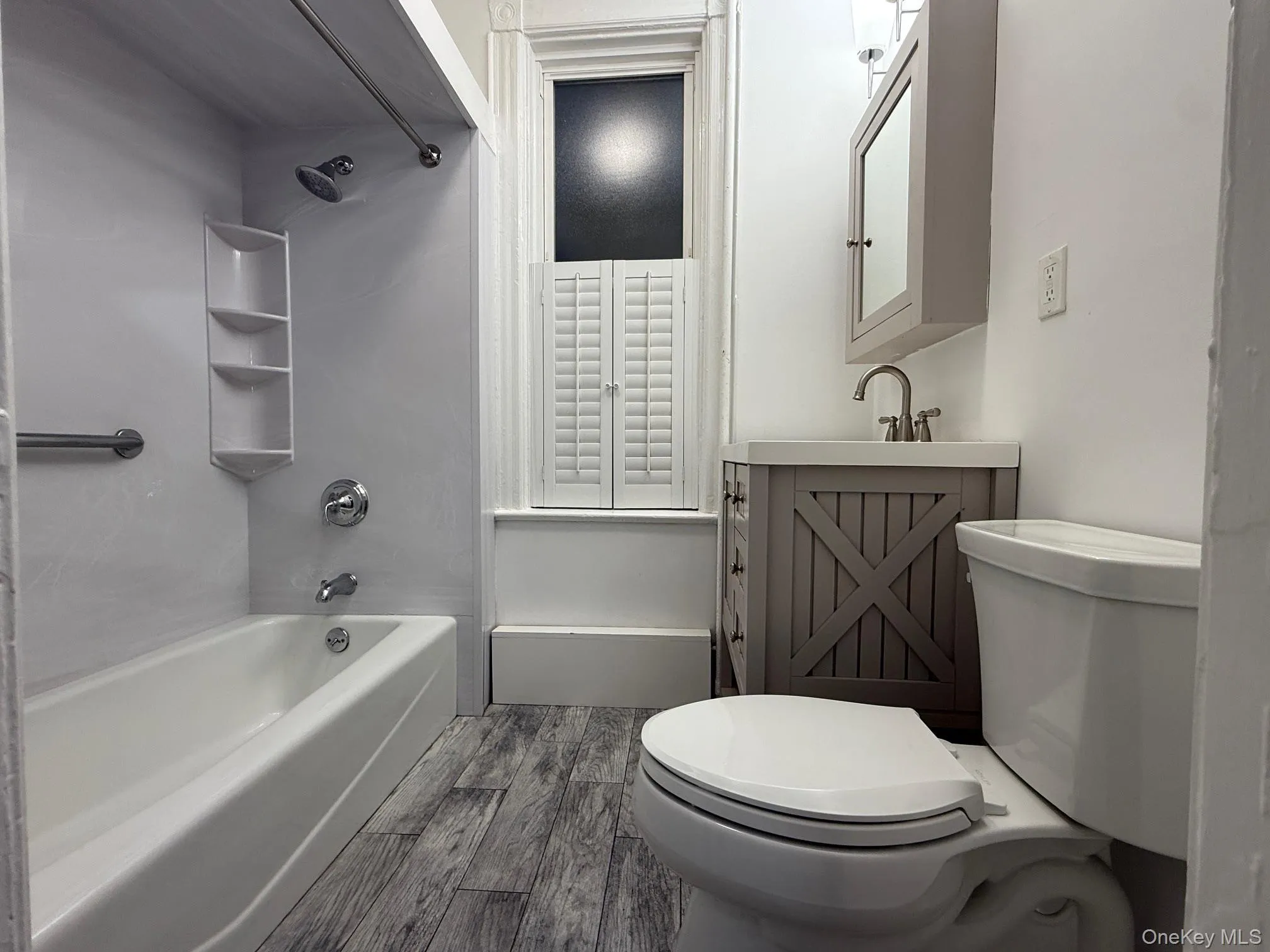 Bathroom with washtub / shower combination, light wood-style flooring, and vanity Bathroom with washtub / shower combination, light wood-style flooring, and vanity