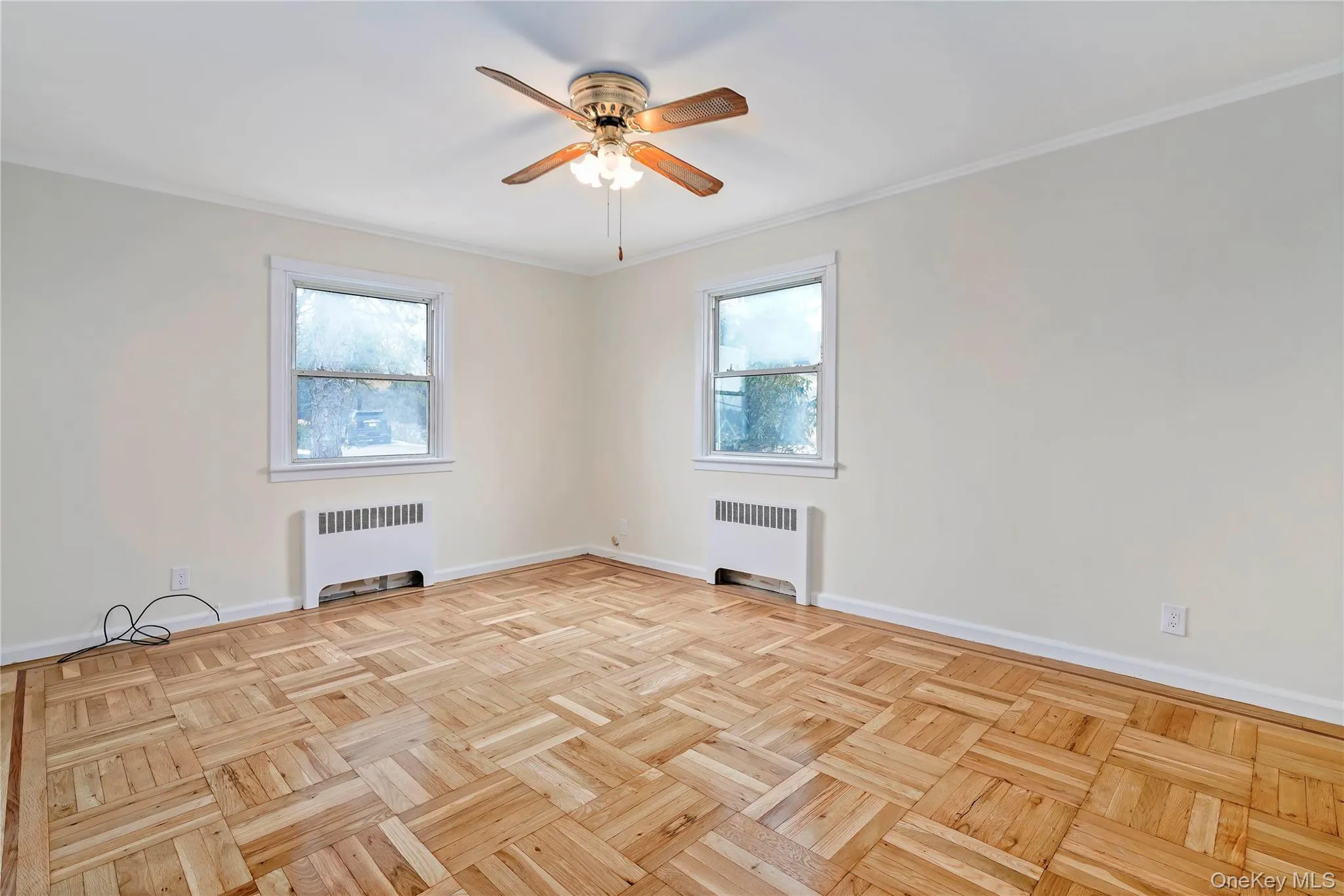 Spare room featuring radiator heating unit, ornamental molding, and a ceiling fan Spare room featuring radiator heating unit, ornamental molding, and a ceiling fan