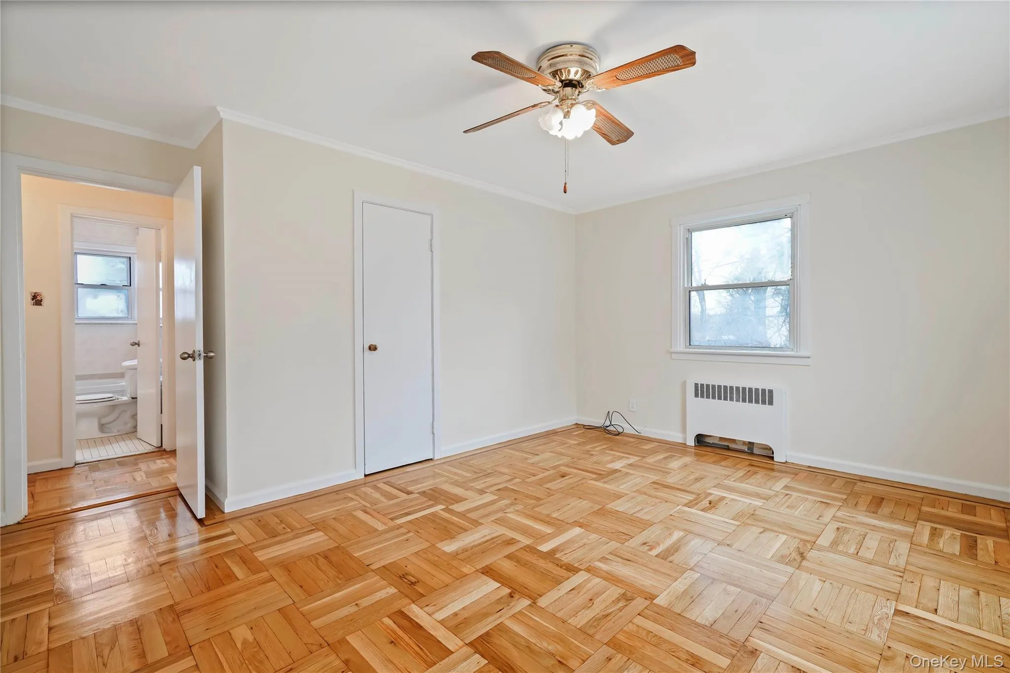 Unfurnished bedroom featuring radiator heating unit, crown molding, and a ceiling fan Unfurnished bedroom featuring radiator heating unit, crown molding, and a ceiling fan