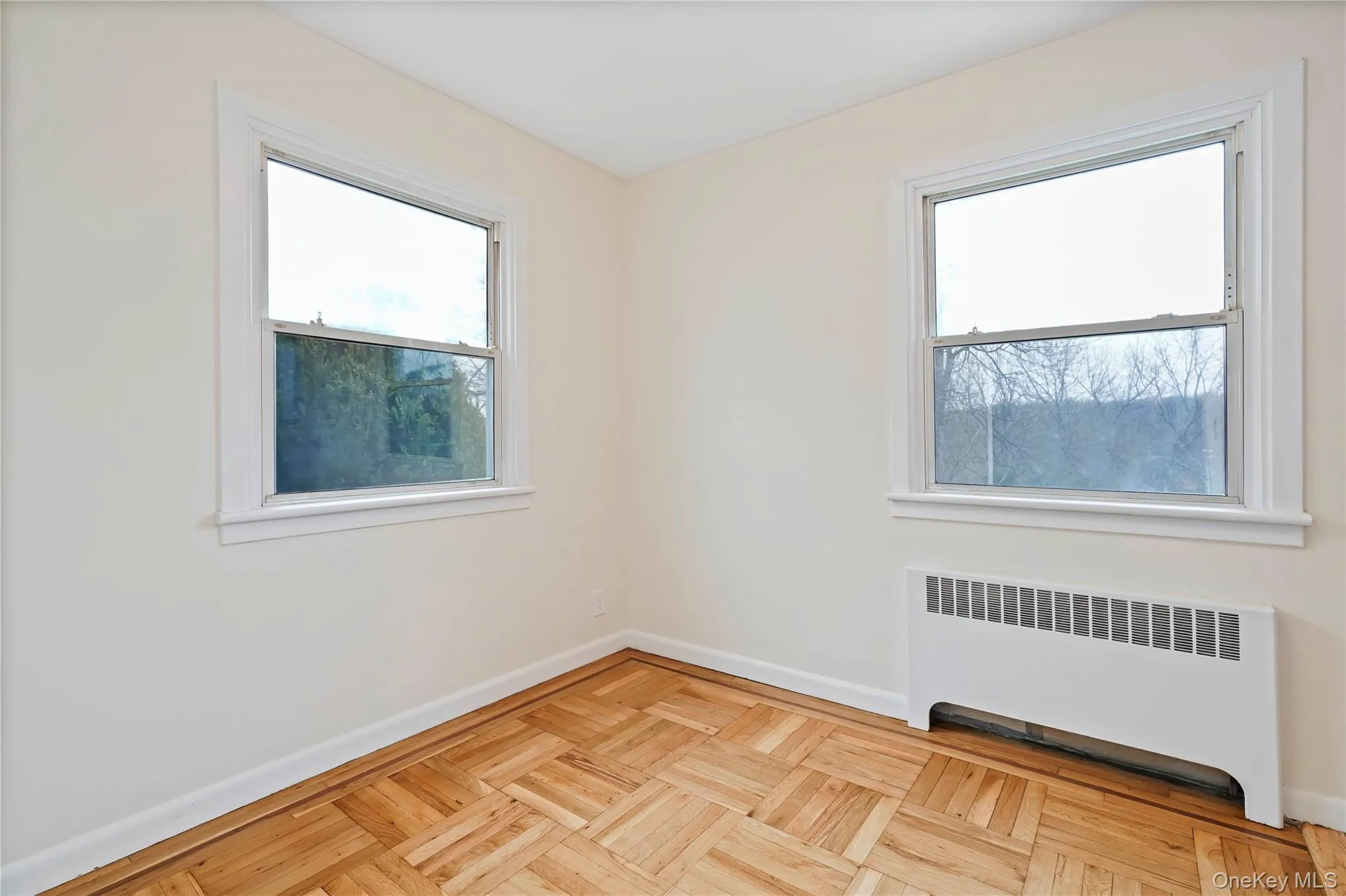 Empty room with radiator heating unit and healthy amount of natural light Empty room with radiator heating unit and healthy amount of natural light