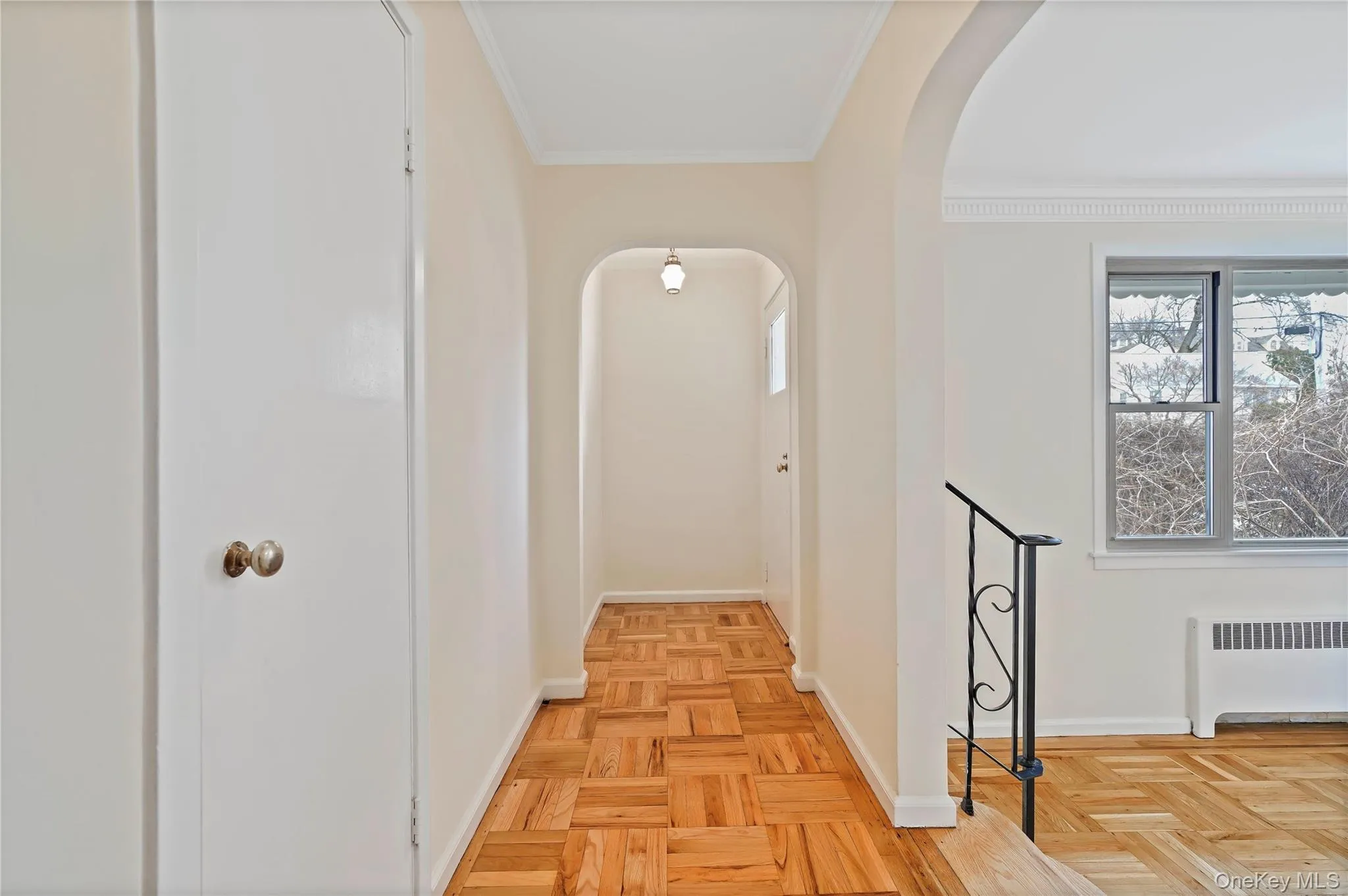 Hallway featuring ornamental molding, and arched walkways Hallway featuring ornamental molding, and arched walkways