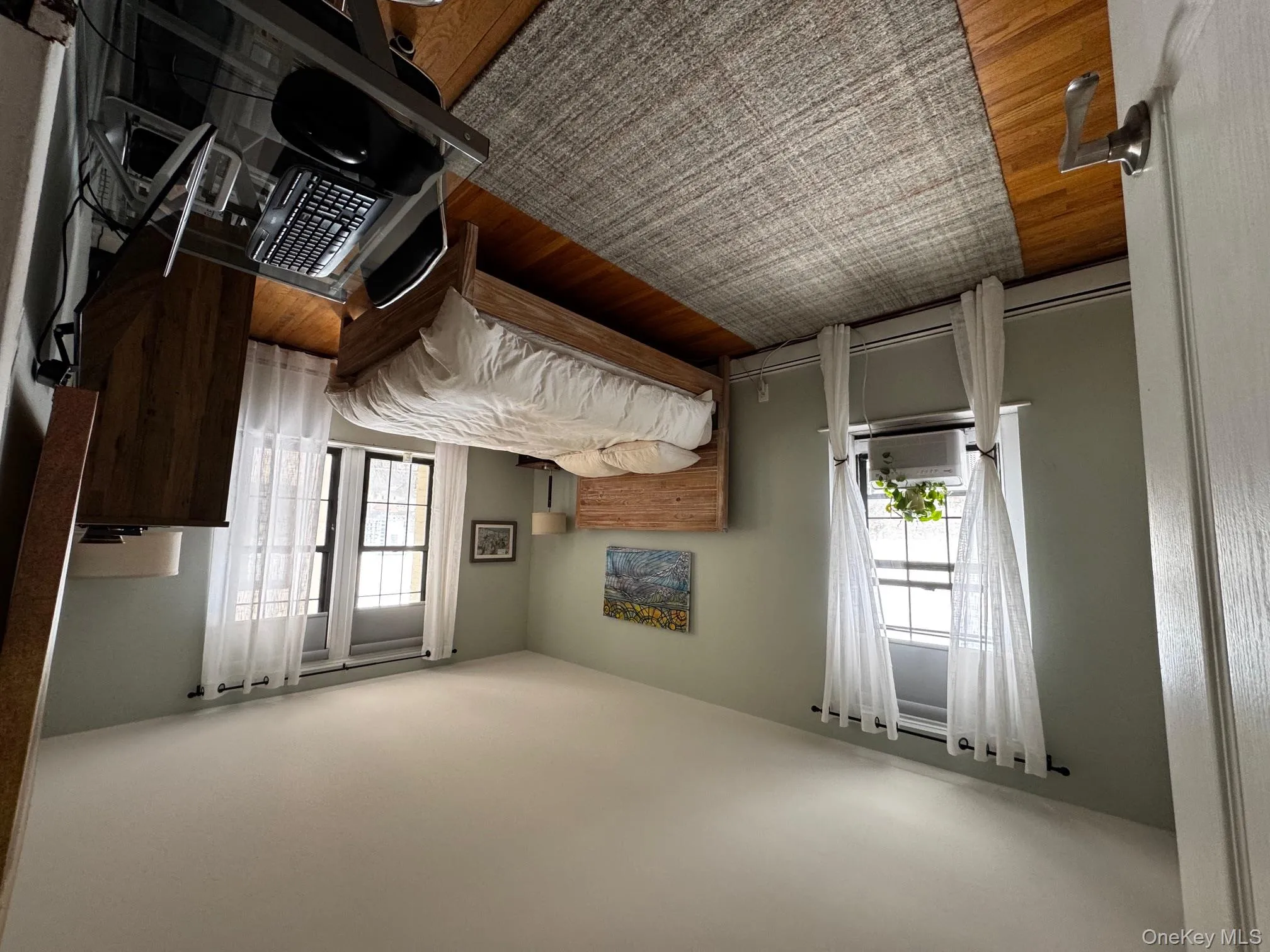 Bedroom featuring cooling unit, baseboards, and wood finished floors Bedroom featuring cooling unit, baseboards, and wood finished floors