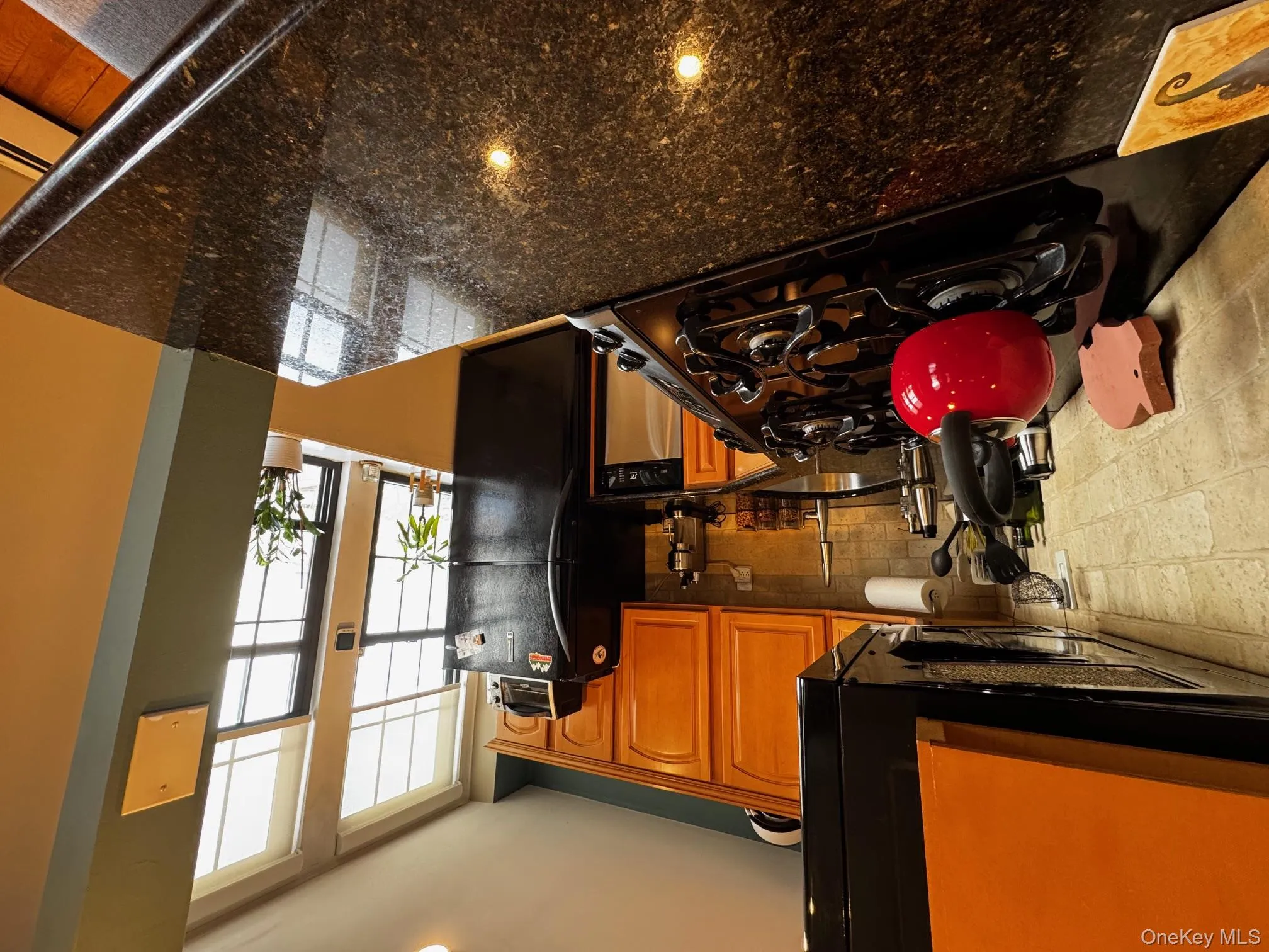 Kitchen with dishwashing machine, a sink, stovetop, freestanding refrigerator, and tasteful backsplash Kitchen with dishwashing machine, a sink, stovetop, freestanding refrigerator, and tasteful backsplash