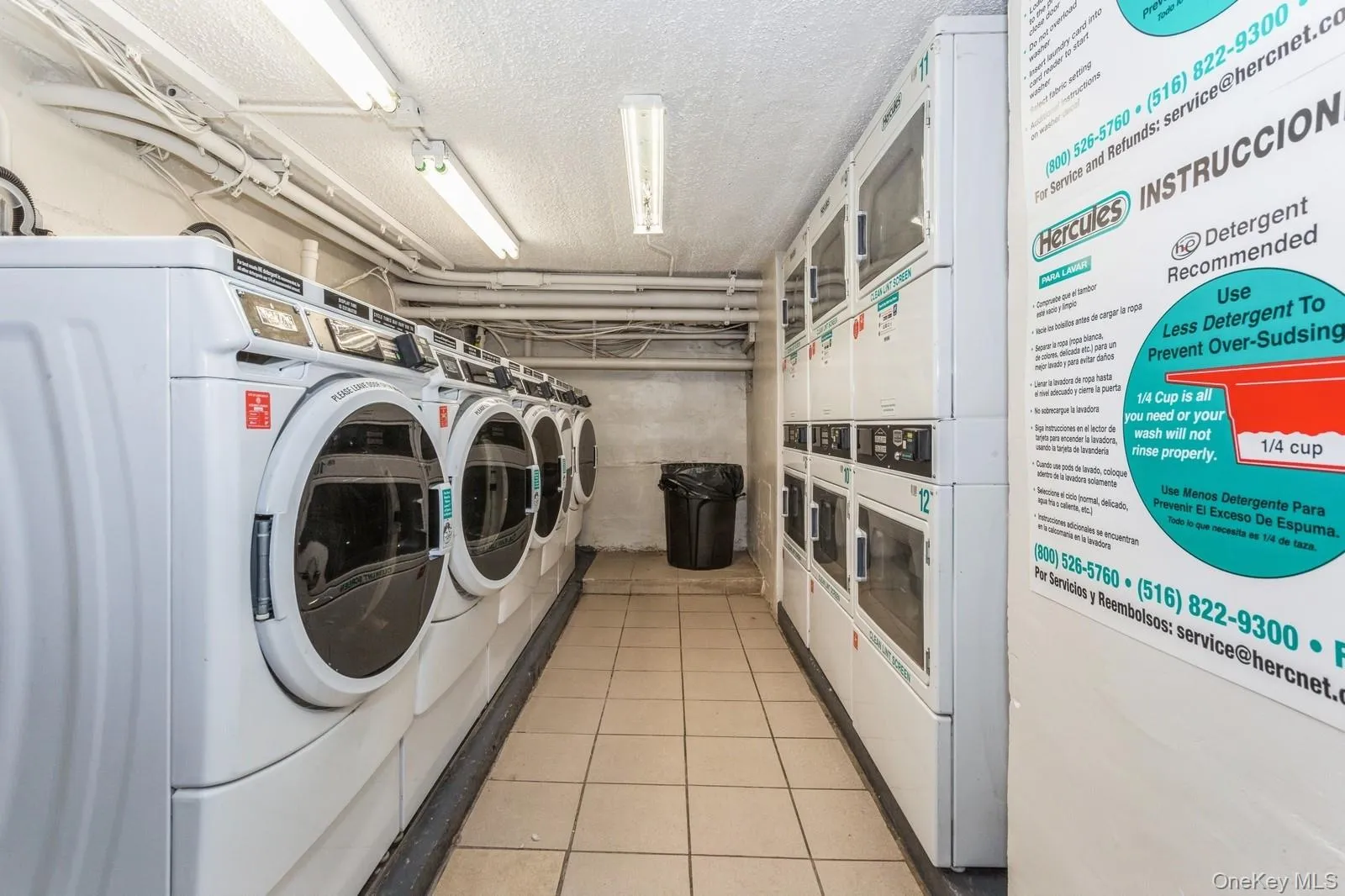 Community laundry room featuring stacked washer / drying machine, washing machine and dryer, light tile patterned flooring, and a textured ceiling Community laundry room featuring stacked washer / drying machine, washing machine and dryer, light tile patterned flooring, and a textured ceiling
