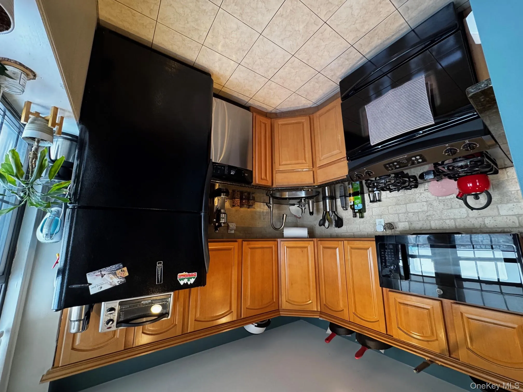 Kitchen featuring stove, a sink, fridge, dishwasher, and dark countertops Kitchen featuring stove, a sink, fridge, dishwasher, and dark countertops