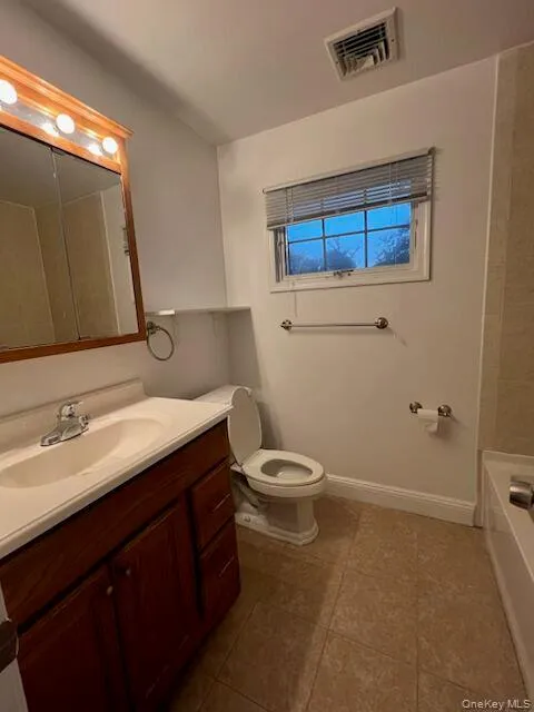 Bathroom featuring vanity and dark tile patterned flooring Bathroom featuring vanity and dark tile patterned flooring