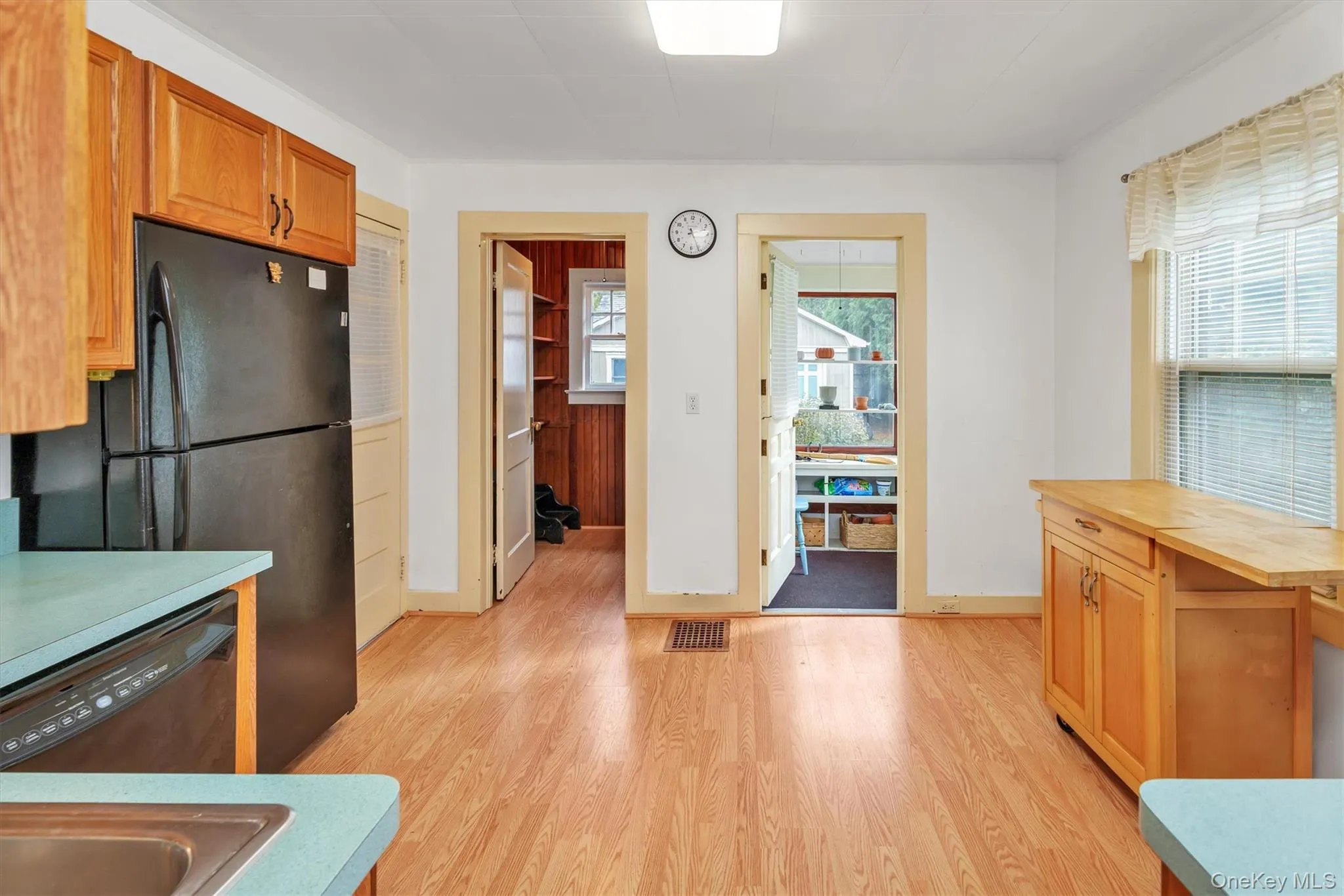 Kitchen featuring black appliances, light wood-type flooring, brown cabinetry, and wooden counters Kitchen featuring black appliances, light wood-type flooring, brown cabinetry, and wooden counters