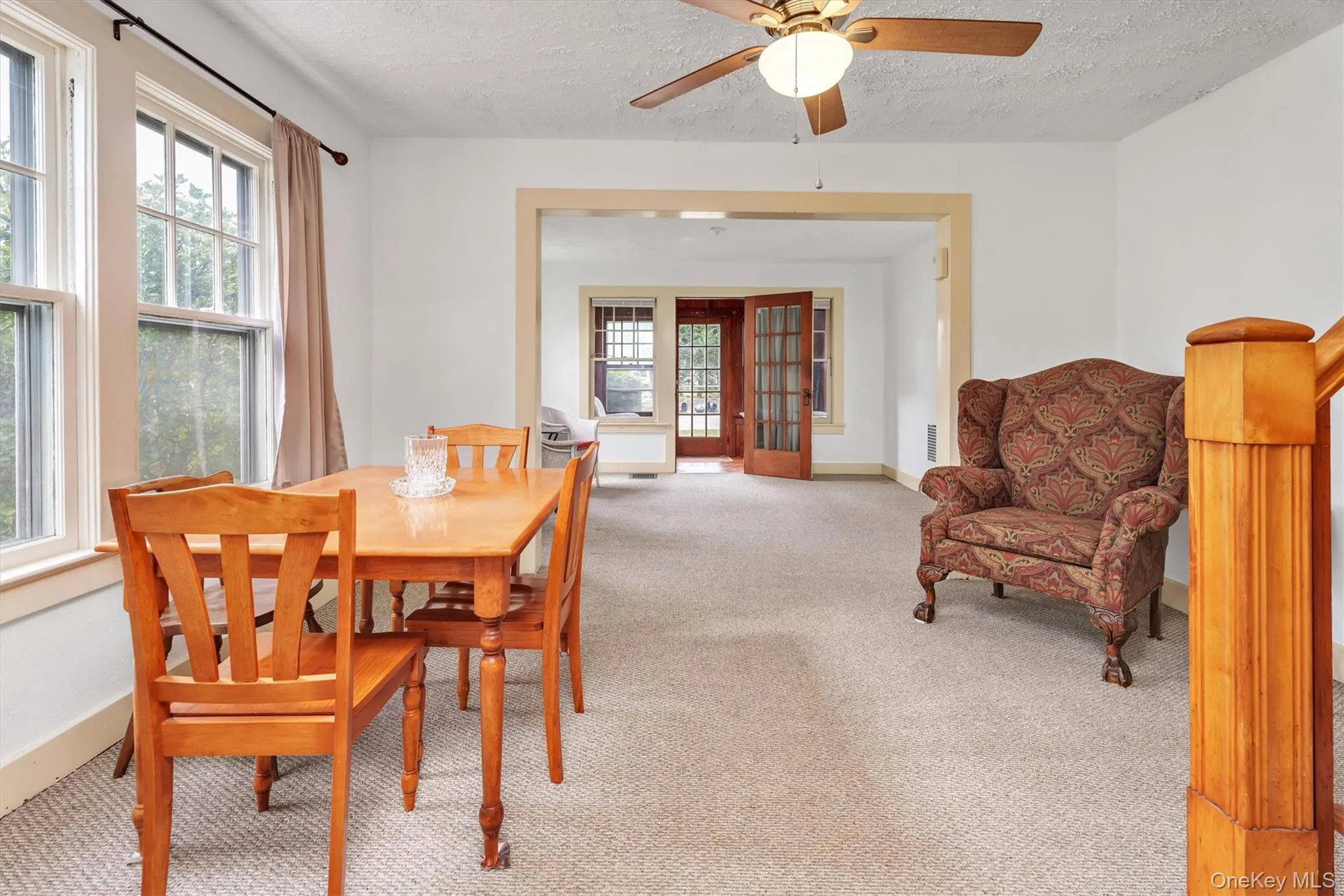 Carpeted dining room featuring a textured ceiling and a ceiling fan Carpeted dining room featuring a textured ceiling and a ceiling fan