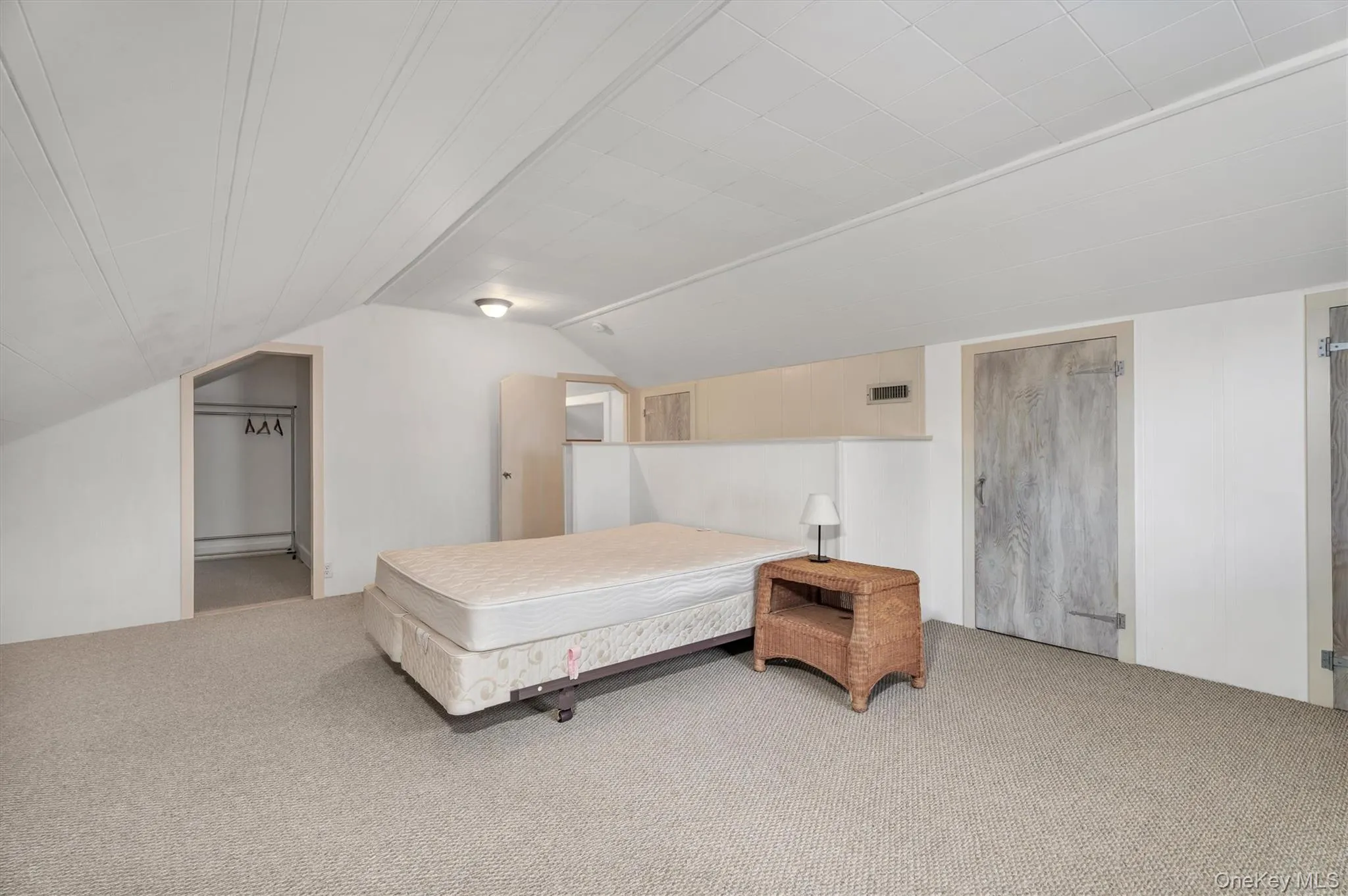 Bedroom with carpet flooring, lofted ceiling, ensuite bathroom, and baseboard heating Bedroom with carpet flooring, lofted ceiling, ensuite bathroom, and baseboard heating