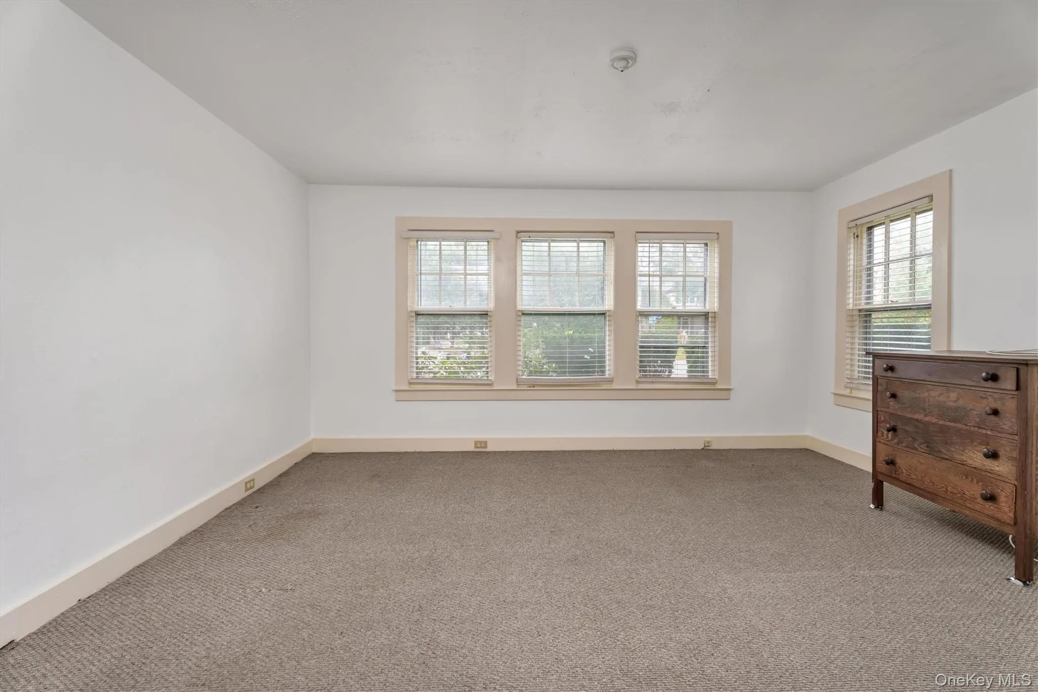 Carpeted empty room featuring plenty of natural light Carpeted empty room featuring plenty of natural light