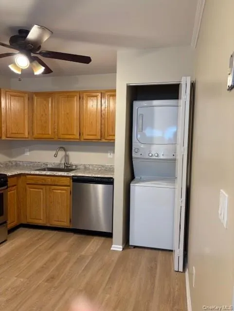 Kitchen with stainless steel appliances, brown cabinets, a ceiling fan, and light wood-type flooring Kitchen with stainless steel appliances, brown cabinets, a ceiling fan, and light wood-type flooring
