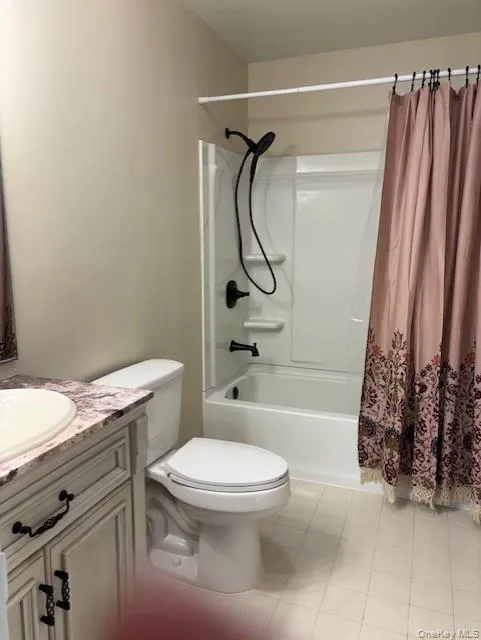 Bathroom with shower / tub combo, vanity, and light tile patterned flooring Bathroom with shower / tub combo, vanity, and light tile patterned flooring