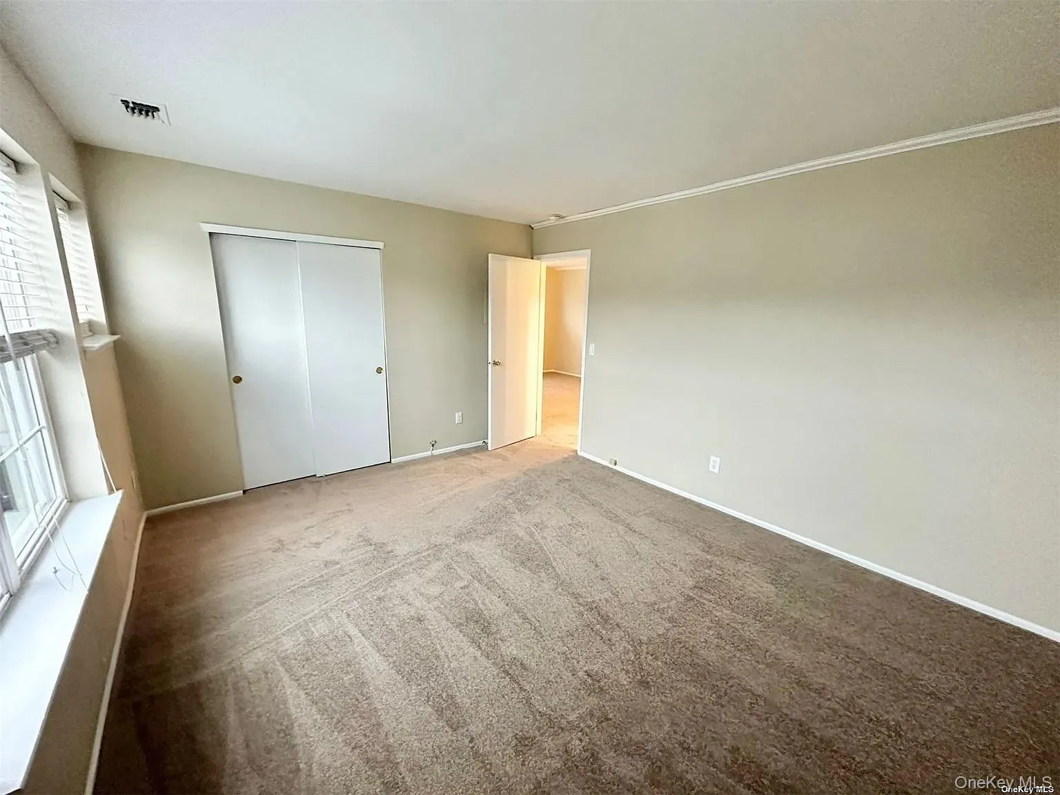Unfurnished bedroom with carpet flooring and a closet Unfurnished bedroom with carpet flooring and a closet
