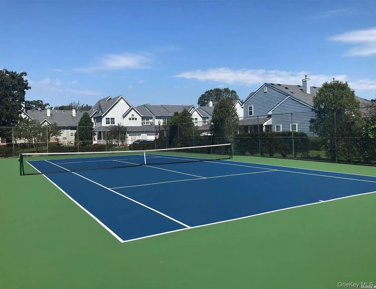 View of tennis court featuring community basketball court and a residential view View of tennis court featuring community basketball court and a residential view