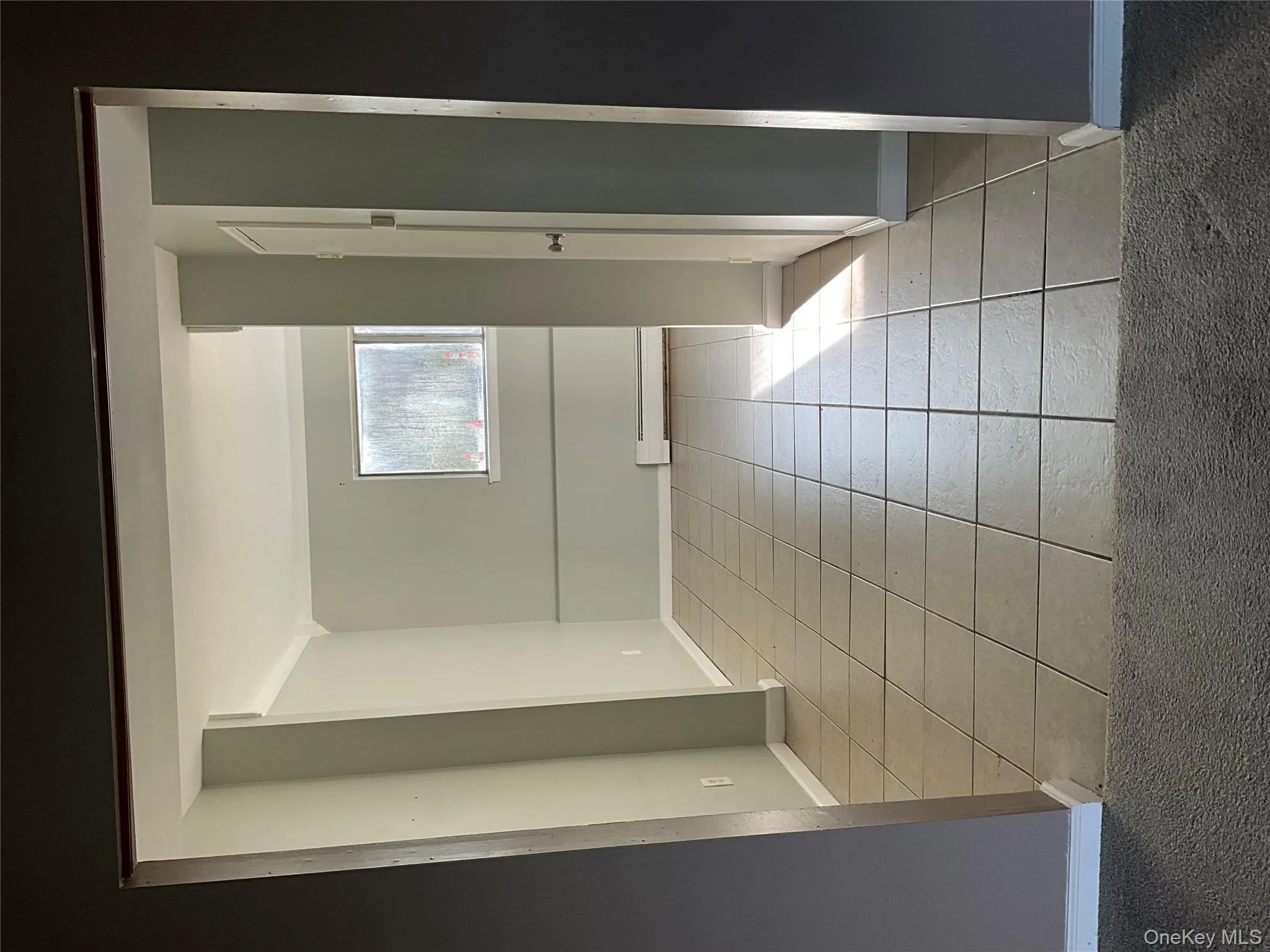 Spare room with light tile patterned flooring, a baseboard heating unit, and light colored carpet Spare room with light tile patterned flooring, a baseboard heating unit, and light colored carpet