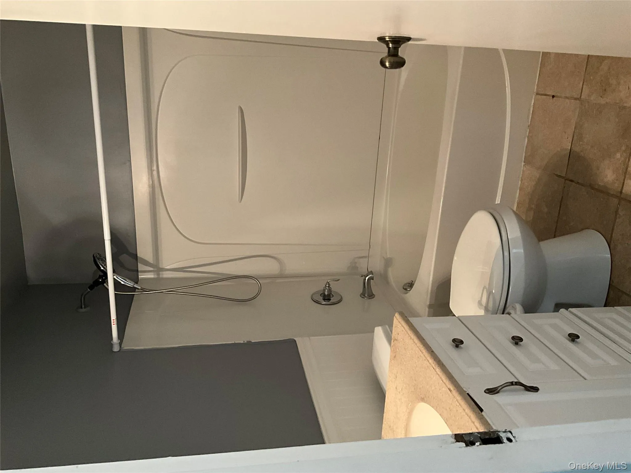 Full bath featuring vanity, bathtub / shower combination, a wainscoted wall, and tile patterned flooring Full bath featuring vanity, bathtub / shower combination, a wainscoted wall, and tile patterned flooring