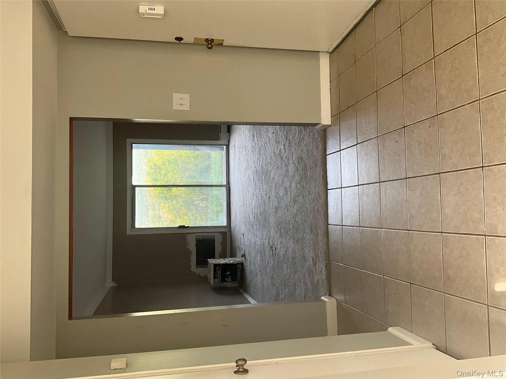 Hallway with baseboards and light tile patterned floors Hallway with baseboards and light tile patterned floors