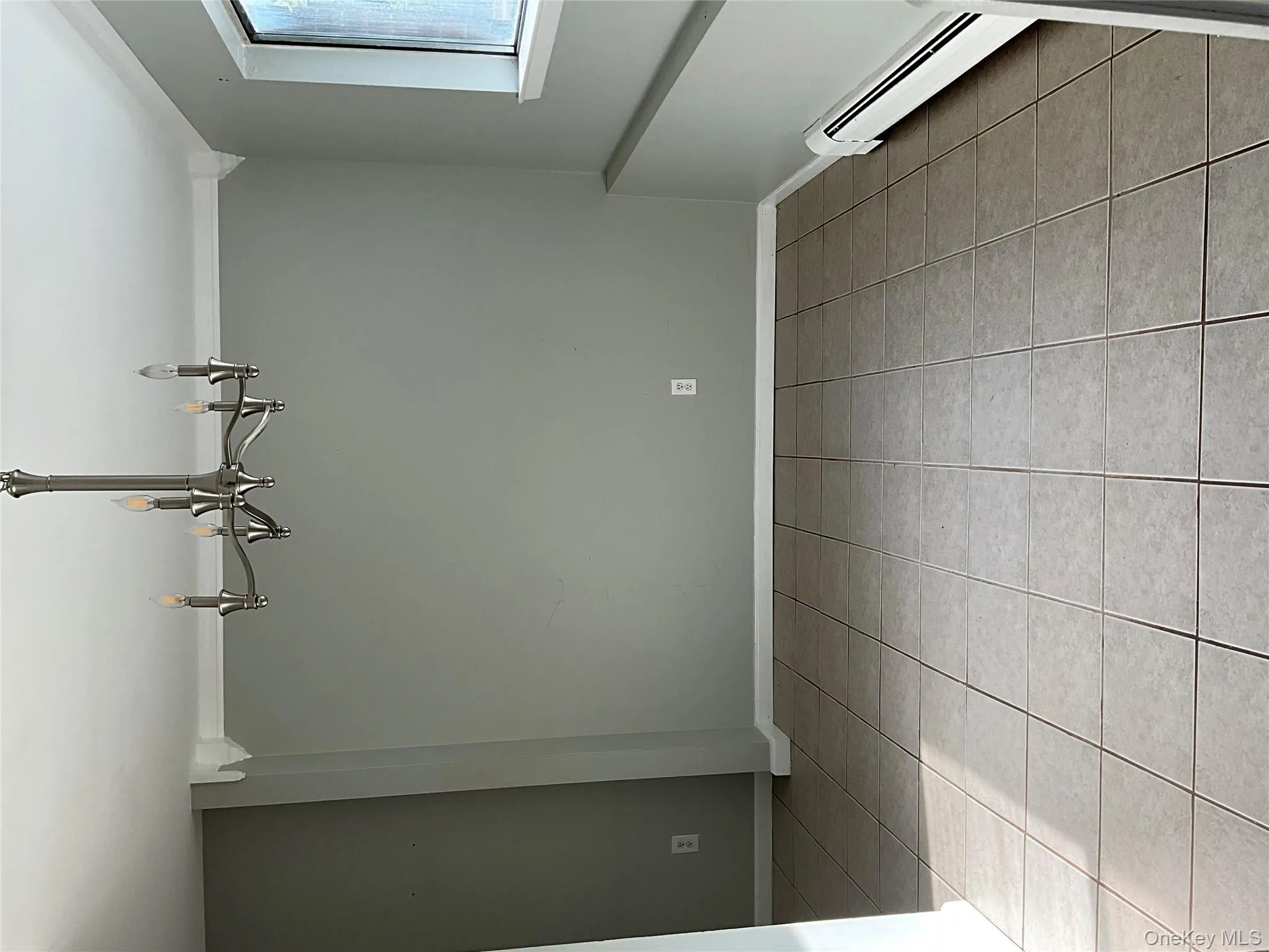 Unfurnished room featuring a baseboard radiator, light tile patterned flooring, a chandelier, and crown molding Unfurnished room featuring a baseboard radiator, light tile patterned flooring, a chandelier, and crown molding