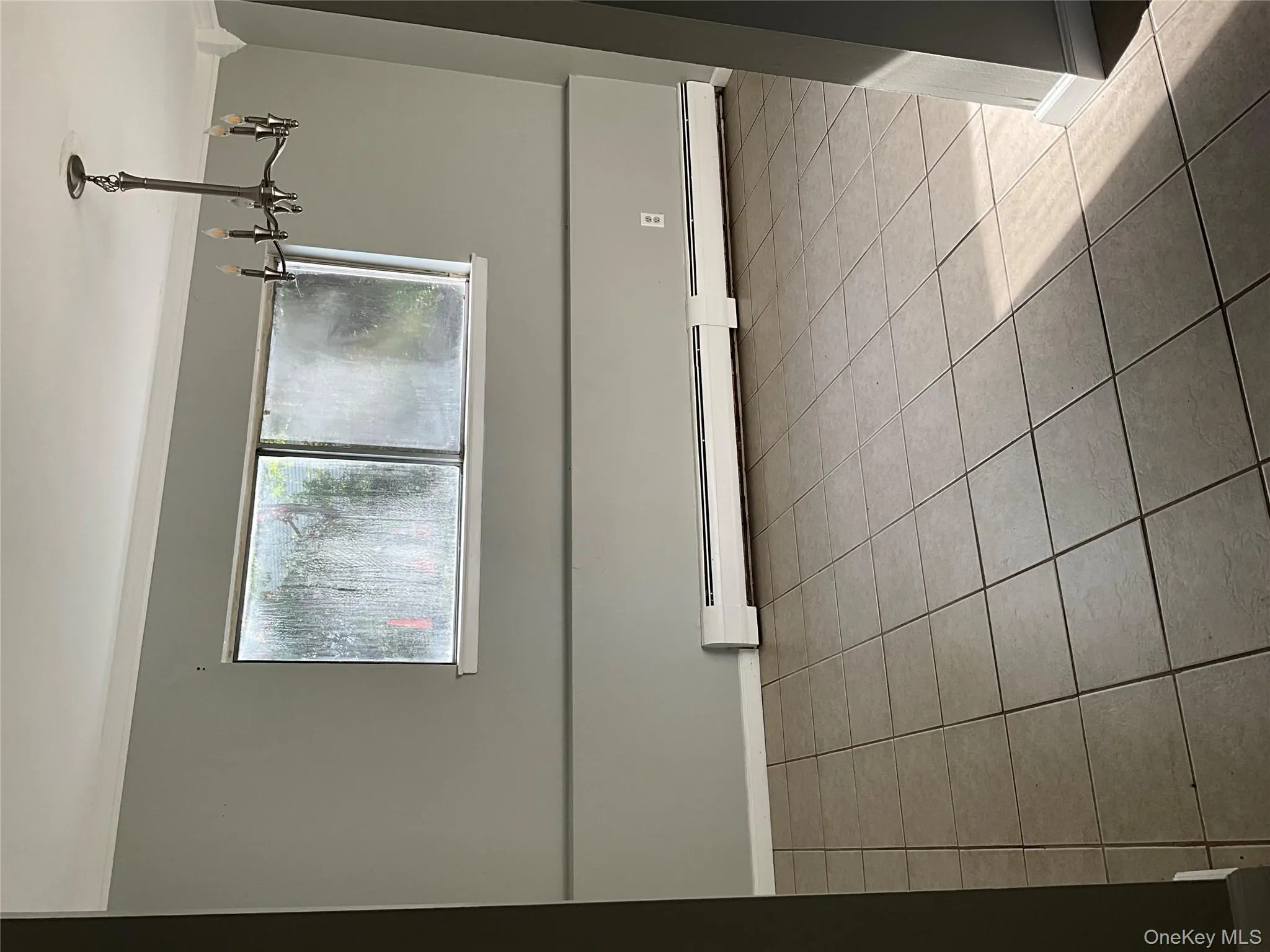 Unfurnished room featuring light tile patterned floors, ornamental molding, healthy amount of natural light, a baseboard heating unit, and a chandelier Unfurnished room featuring light tile patterned floors, ornamental molding, healthy amount of natural light, a baseboard heating unit, and a chandelier