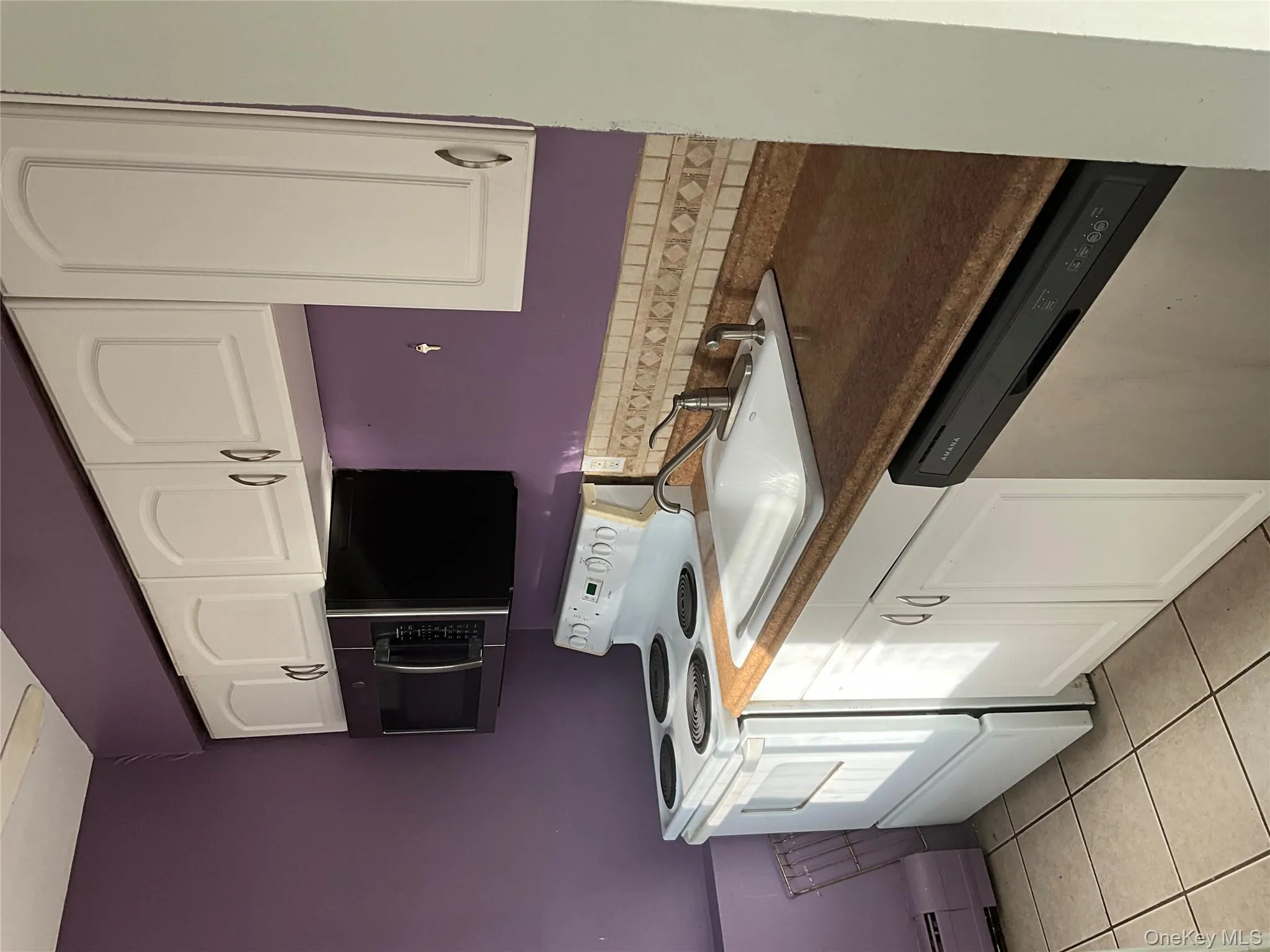 Kitchen with stainless steel range oven, dark countertops, dishwasher, and white cabinets Kitchen with stainless steel range oven, dark countertops, dishwasher, and white cabinets