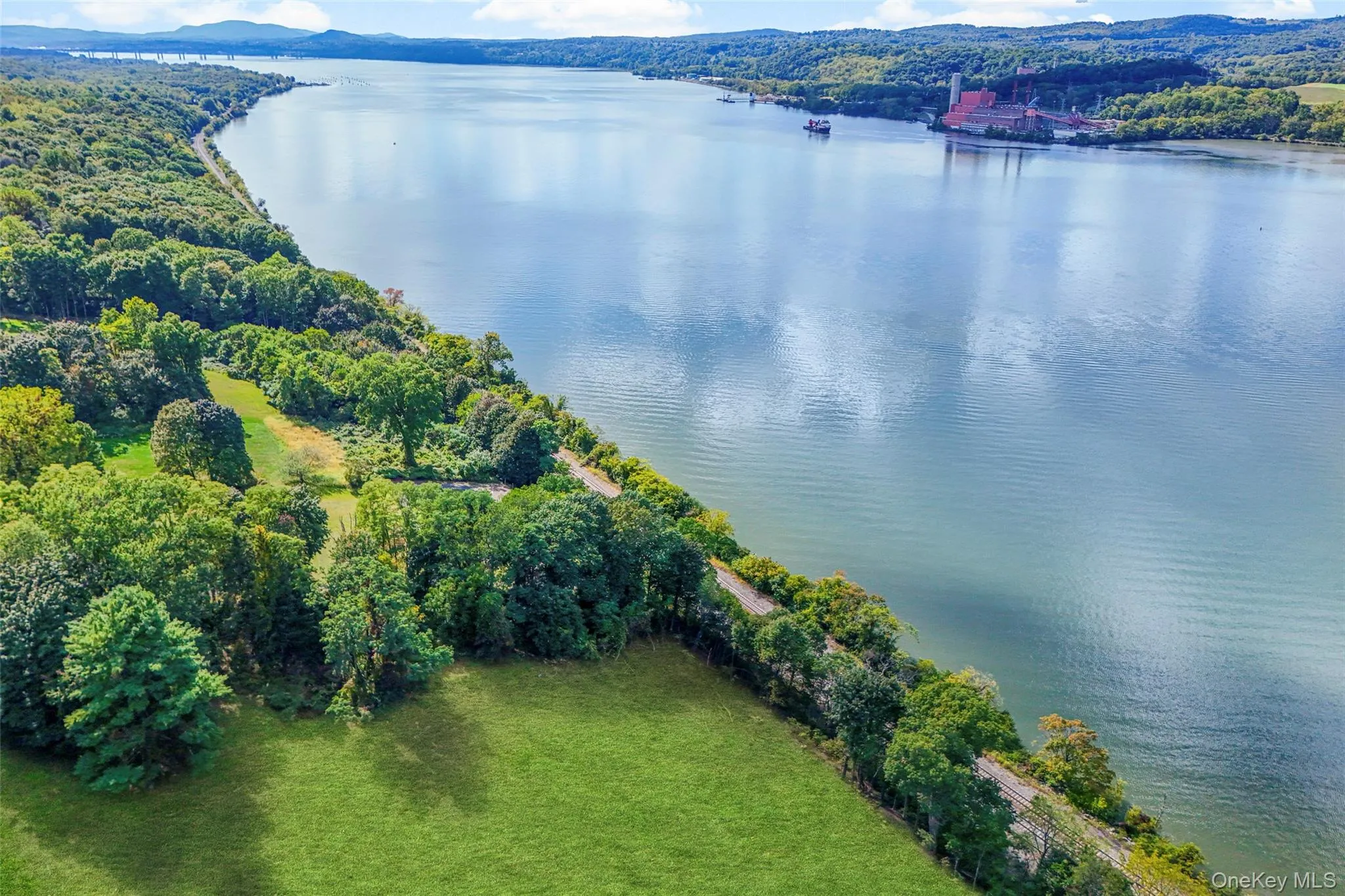 Aerial view of a nearby body of water and a heavily wooded area Aerial view of a nearby body of water and a heavily wooded area