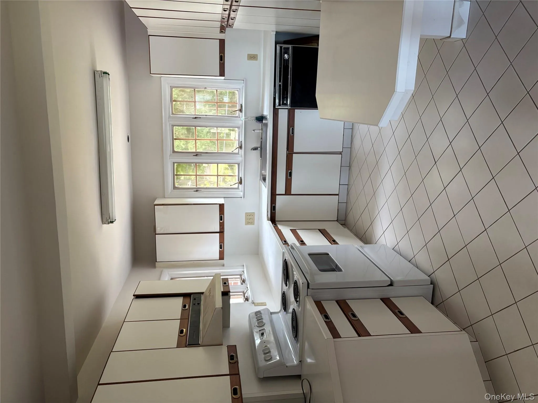 Kitchen with white cabinetry, range, and light countertops Kitchen with white cabinetry, range, and light countertops