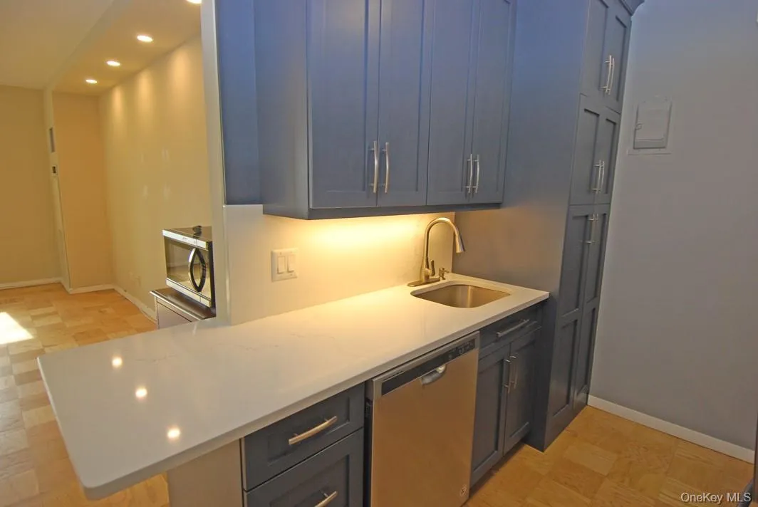 Kitchen with recessed lighting, stainless steel appliances, light stone countertops, and a peninsula Kitchen with recessed lighting, stainless steel appliances, light stone countertops, and a peninsula