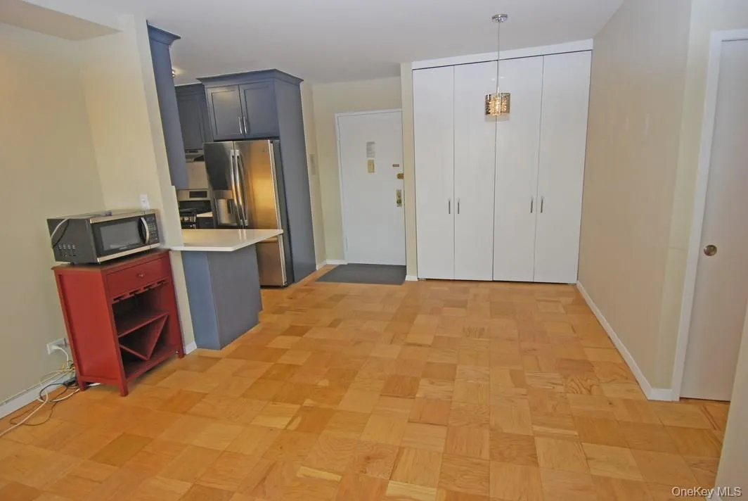 Kitchen with stainless steel appliances, decorative light fixtures, a peninsula, and light stone counters Kitchen with stainless steel appliances, decorative light fixtures, a peninsula, and light stone counters