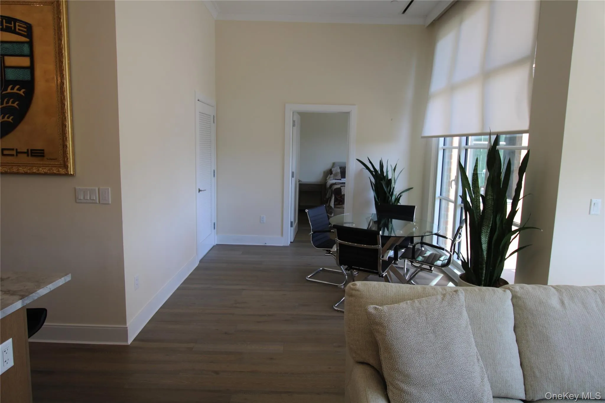 Living area featuring dark wood-style floors, crown molding, a high ceiling, and a desk Living area featuring dark wood-style floors, crown molding, a high ceiling, and a desk