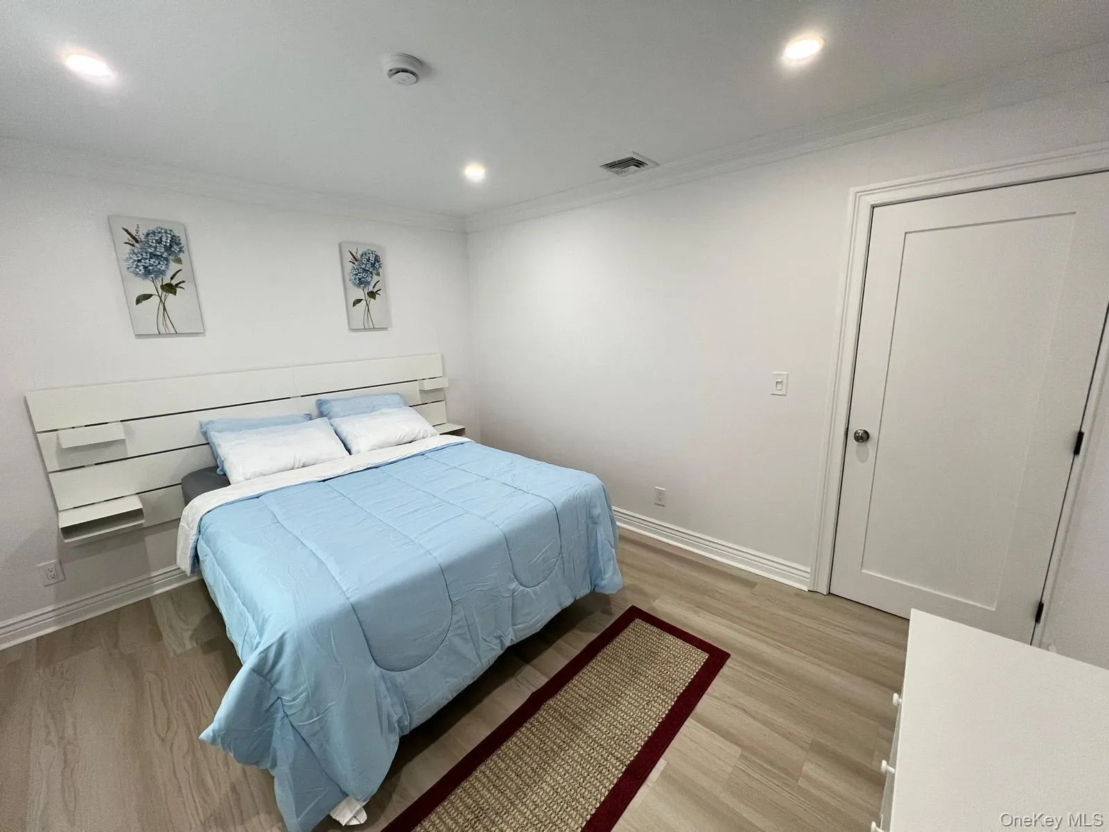 Bedroom with light wood-type flooring, crown molding, and recessed lighting Bedroom with light wood-type flooring, crown molding, and recessed lighting