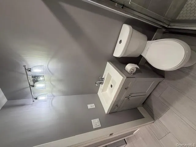 Bathroom with vanity, a shower stall, and wood finish floors Bathroom with vanity, a shower stall, and wood finish floors