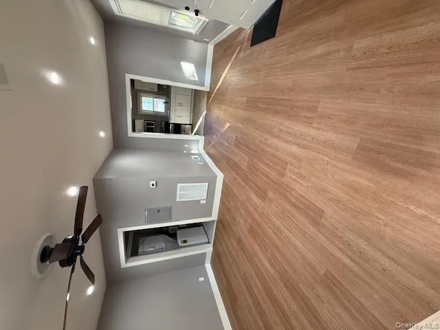Unfurnished living room featuring recessed lighting, light wood-style flooring, a ceiling fan, washer / clothes dryer, and electric panel Unfurnished living room featuring recessed lighting, light wood-style flooring, a ceiling fan, washer / clothes dryer, and electric panel