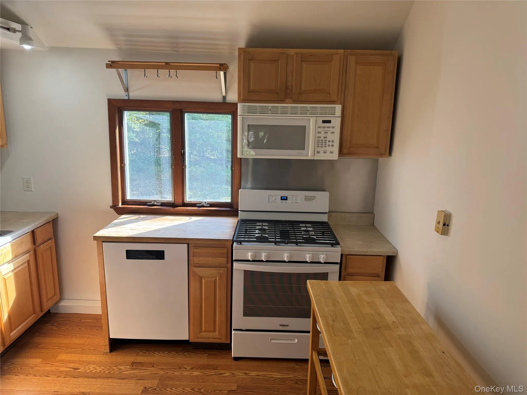 Kitchen featuring white appliances, wood counters, dark wood finished floors, and brown cabinets Kitchen featuring white appliances, wood counters, dark wood finished floors, and brown cabinets