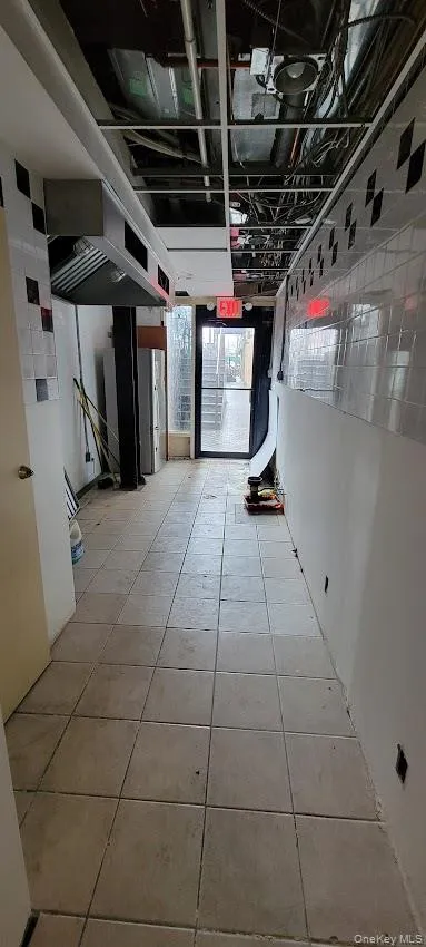Hallway featuring light tile patterned floors Hallway featuring light tile patterned floors