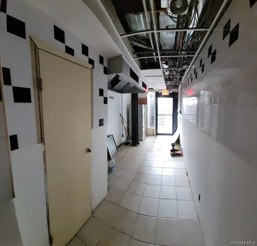 Hallway featuring light tile patterned floors Hallway featuring light tile patterned floors
