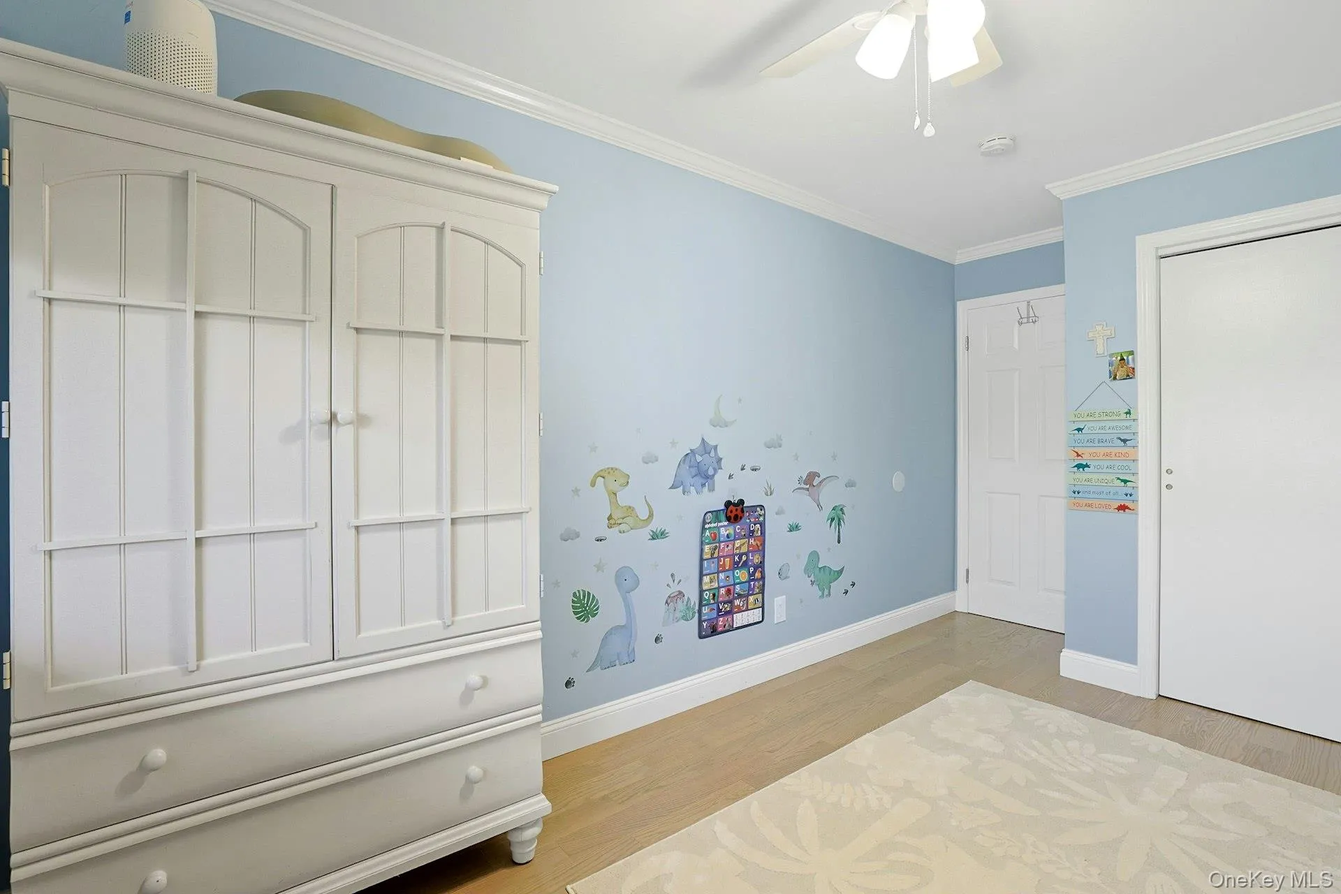 Bedroom featuring ornamental molding, light wood-style floors, and ceiling fan Bedroom featuring ornamental molding, light wood-style floors, and ceiling fan