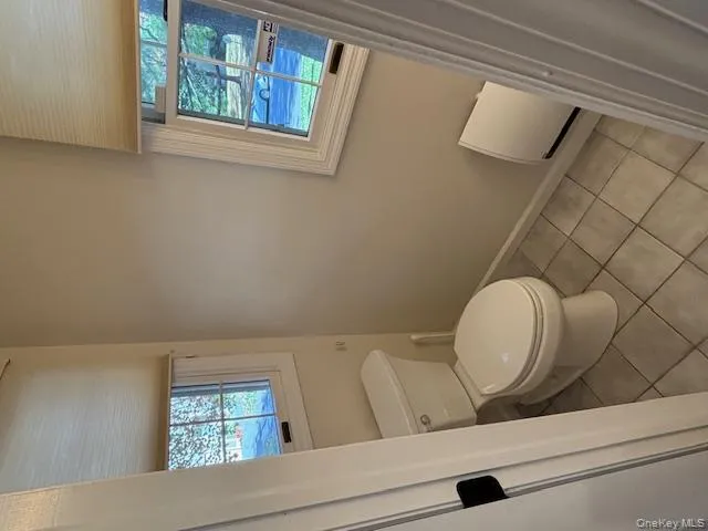 Bathroom featuring toilet and light tile patterned floors Bathroom featuring toilet and light tile patterned floors