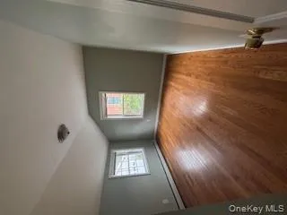 Additional living space featuring wood finished floors, vaulted ceiling, and a baseboard heating unit Additional living space featuring wood finished floors, vaulted ceiling, and a baseboard heating unit