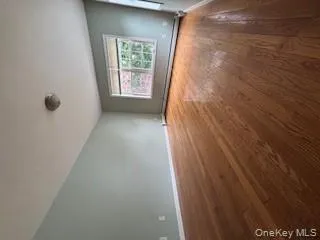 Unfurnished room featuring dark wood-style flooring and a baseboard radiator Unfurnished room featuring dark wood-style flooring and a baseboard radiator